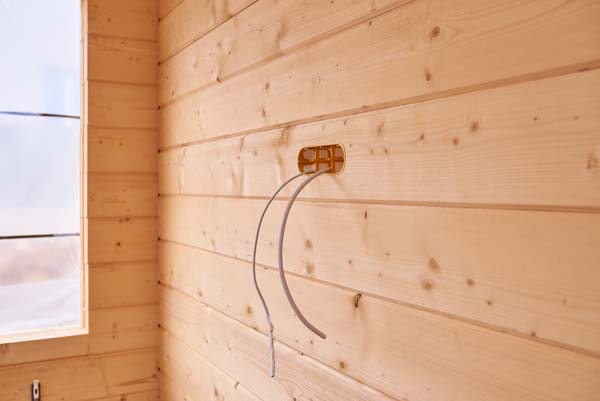 installation of electrical wiring socket inside a wooden house