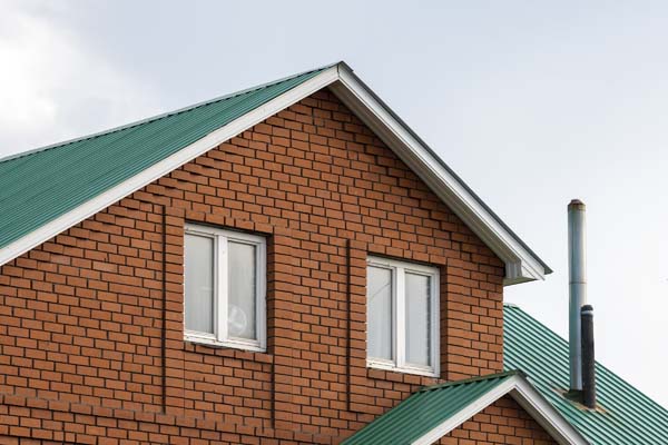 Red brick house with green roof. Traditional european cultures architecture.